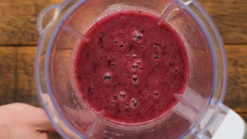Slow Motion Of Blueberry Acai Berry Smoothie Rotating In Blender. Preparation Of Healthy Raw Vegan Smoothie. Top View