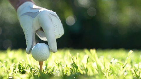 Putting golf ball on green grass