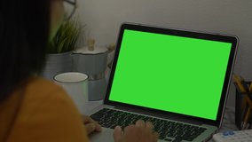 Over the shoulder shot of a business woman working in office interior on pc on desk, looking at green screen. Office person using laptop computer with laptop green screen, - Powered by Shutterstock - Get 15% off with code: PIKWIZARD15