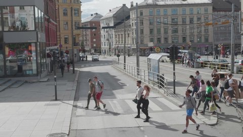 Oslo / Norway - 08 20 2018: Slowmotion of Pedestrians on Crossing in Downtown Area, View From Moving Vehicle
