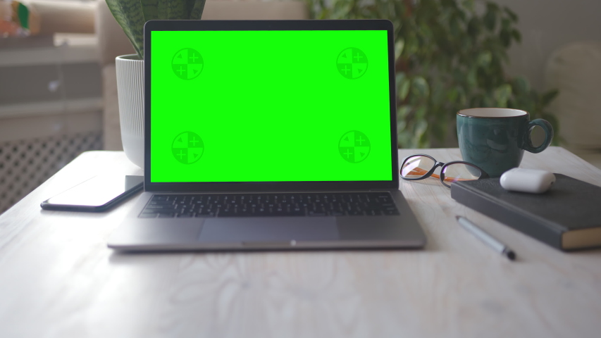 Mock-up Laptop Computer with Chroma Key Green Screen Set on Working Space in Home Office. A Cup of Hot Coffee near the Computer. Concept of Working from Home. Zoom in Shot. | Shutterstock HD Video #1054552025