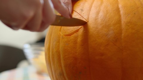 Стоковое видео: A Lady Gently Carving An Orange Pumpkin With A Small Knife - Closeup Shot
