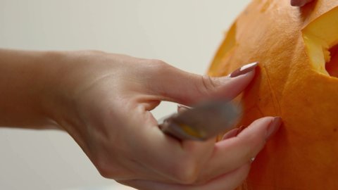 Woman Removing The Carved Nose Of A Pumpkin While Holding A Knife, Making A Jack-O-Lantern Halloween Decoration - Closeup Shot Arkivvideo