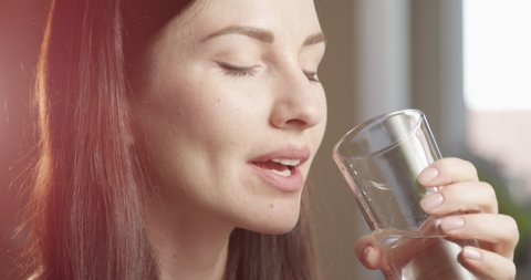 Thirsty Woman Drinking Water from a Glass Indoors with Sun Shining a Close up Shot on Red Camera