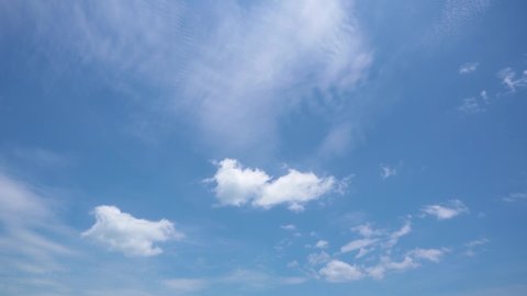 Light white clouds fly across a bright blue sky. Clear sky at sunny summer afternoon. Spring cloudscape background. Copy space