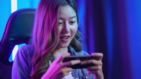 Young asian woman Pro Gamer win the game playing mobile game on the smartphone 4k resolution