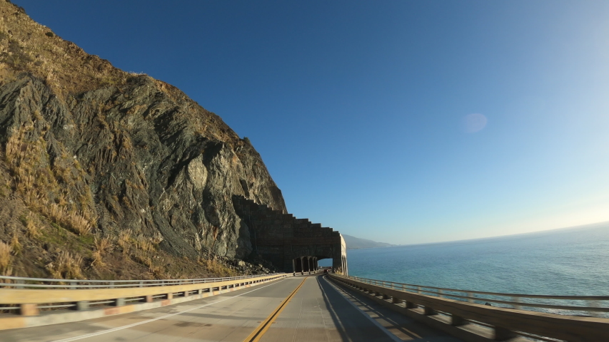 Big Sur California Arch driving inCabrillo Highway 1 coast road, pov south, tunnel Royalty-Free Stock Footage #1054577501