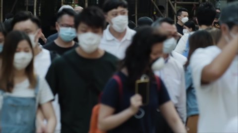 Slow motion of unrecognized people wearing medical face masks in Hong Kong. Coronavirus concept