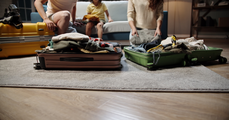 Funny asian family of three is preparing for their travel adventure, packing clothes into suitcase, getting ready for road trip - travelling, happy family concept 4k footage Royalty-Free Stock Footage #1054581929