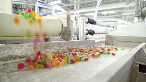 colorful marmalade rolls on the conveyor. production line. confectionery factory.