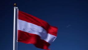 4K: Austria Flag flying in the wind outdoors with Blue sky behind - Austrian flag on flagpole.  Stock 4K Video Clip Footage