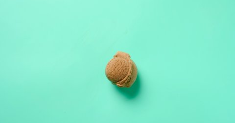 chocolate ice cream ball melting on light green background timelapse at 8K 17 to 9 ratio