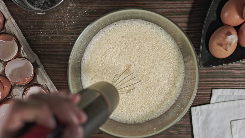 Kneading the dough. The process of making a delicious treat or dessert. Ingredients for baking on the table. Top plan for chef cook. Home cooking with care for relatives. Royalty-Free Stock Footage #1054585937