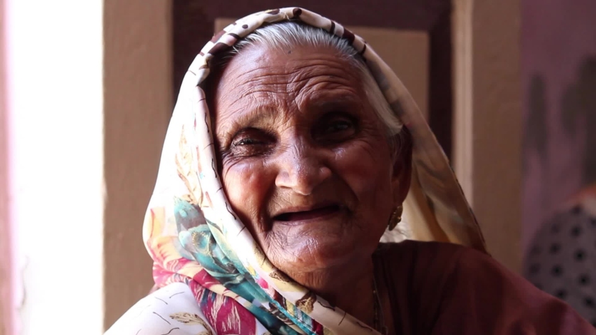 Old Indian woman wearing saree laughing while staring at the camera	 | Shutterstock HD Video #1054588892