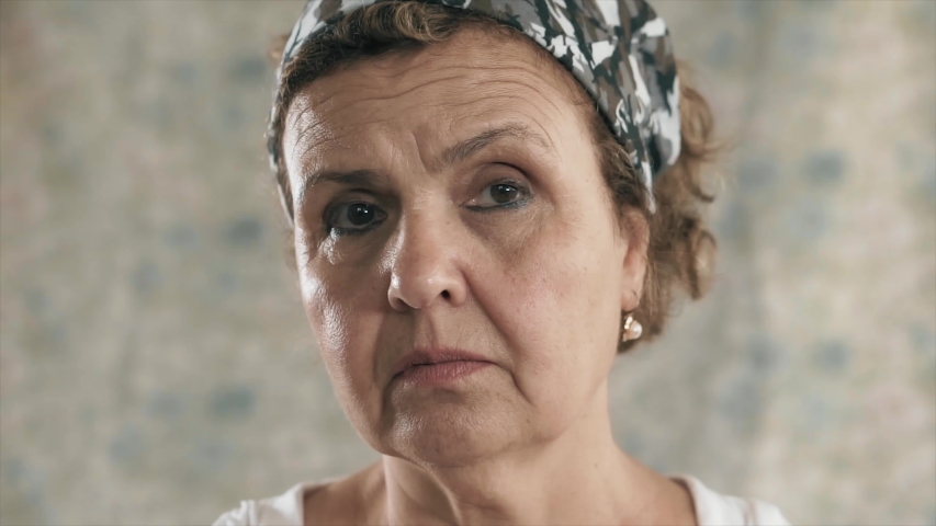 Angry old woman looking to camera seriously. Face portrait, anger, depressed old senior person close up shot. S3niorLife Royalty-Free Stock Footage #1054599149