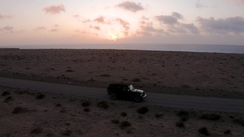 Aerial of Jeep driving off-road during sunset in Fuerteventura, Spain