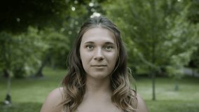 Portrait of a young caucasian mother. Shot in a beautiful park in slow-motion and 4k. 