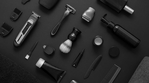 Mens beauty and health concept. Various shaving and bauty care accessories placed on black background. With shaver, brush, cream, towel and other. Top view flat lay.