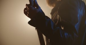 Close-up of bass player making a solo. An experienced musician starring on stage with rock music, lit by red and blue neon lights - music, hobby concept 4k footage