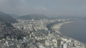Drone, tracking shot of Copacabana and slums on the hills of Rio de Janeiro in Brazil