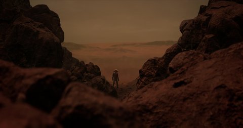 DOLLY IN Back view of lonely astronaut walking on a surface of a red rocky planet. Mars colonization concept. Dust effect added