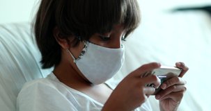Boy playing video-game during pandemic.