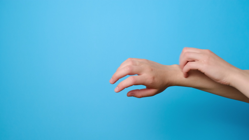 Close up of unrecognizable young woman scratches her hands isolated on blue studio background with copy space. Signs of dermatitis and scabies. Concept skin allergy Royalty-Free Stock Footage #1054632656