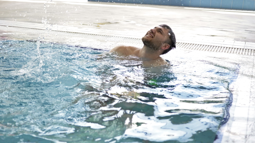 Cheerful middle-aged man enjoys spending time in the indoor pool.