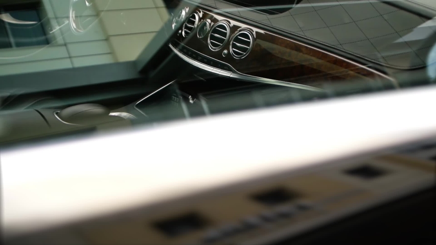 A shot through the glass of a wooden dashboard of an expensive business class car. | Shutterstock HD Video #1054661102