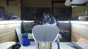 Surfboard making, Shaper using a foam sander tool on the bottom of the surfboard. Concept of craftsmanship, small business in America, craftsman at work. - Powered by Shutterstock - Get 15% off with code: PIKWIZARD15