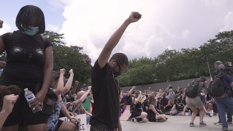 Washington D.C./USA- June 19th, 2020: Black Lives Matter protesters holding fist in the air and kneeling at the MLK memorial.