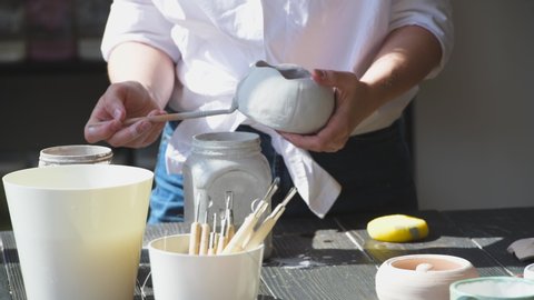 Production process of pottery. Application of glaze brush on ceramic ware.