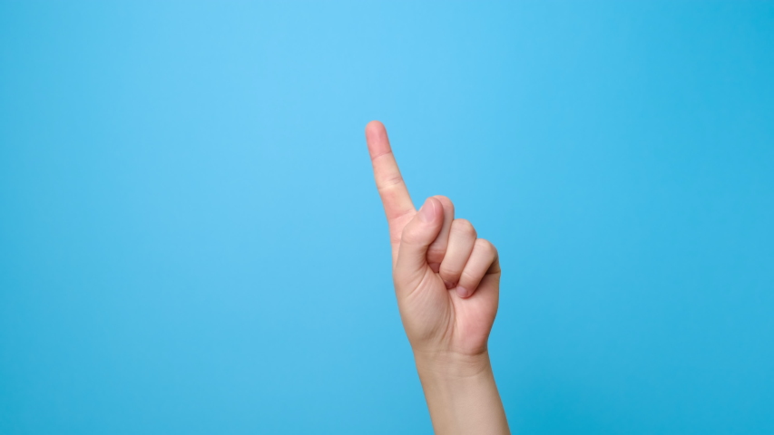 Finger signal. Close up of female hand showing no, isolated on blue studio background with copy space for advertisement. Disapproving gesture. Advertising area, mock up. Royalty-Free Stock Footage #1054675868