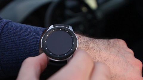 Close up mans hands opening a map on Samsung Galaxy watch in a car. Modern device for traveling. Navigation in a smartwatch, Berlin, May 2020