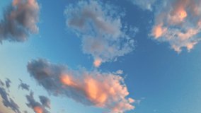 Cumulus clouds rotates on brilliant blue sky at sunset.