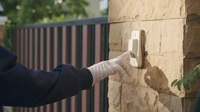 The male employees hand pressed ring the bell in front of the customer house, Men wear hand gloves to prevent the spread of the virus. - Powered by Shutterstock - Get 15% off with code: PIKWIZARD15