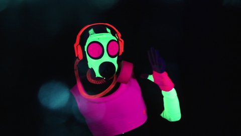 Person wearing protective gas mask during pandemic dancing in nightclub