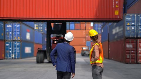 Engineer woman with Business man control loading Container from Cargo freight ship for import and export , support logistics transportation concept.