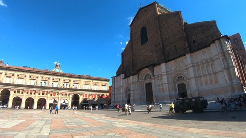 Bologna time lapse in 4k: view of St. Petronio church or cathedral ( basilica di san petronio) in the main square ( piazza maggiore) during a sunny day. Blue clear sky with some clouds in background