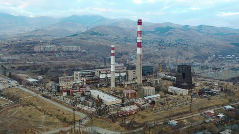 Aerial view industrial zone.The industry is closed and not used. Factory with mountains background.Birds Eye View , Aerial Drone Flying Over empty factory.