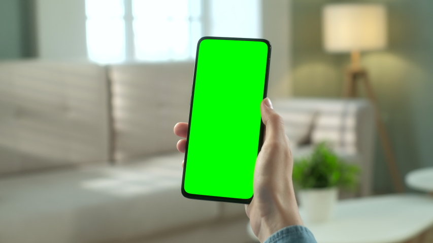 Point of View of Woman at Phone with Green Screen for Copy Space. Chromakey Mock Up Without Tracking Markers. 20s Lady Watching Video News on Couch Close up. Double Swipe Up