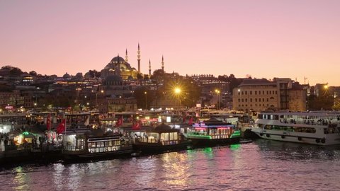 Suleymaniye Mosque and balik ekmek floating cafe boats at twilight. Istanbul cityscape at night, Turkey. Evening time in Eminonu district. 