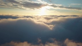 Aerial shot above the clouds in 4k while sunset.