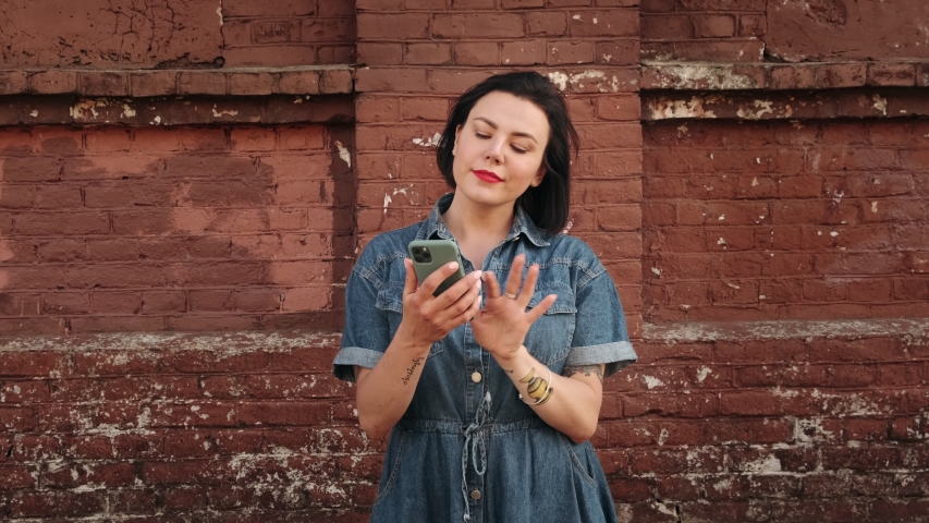 Amazed lucky woman using phone looks and sees the message with a good news. Happy female is surprised, rejoices and  jumps.  Royalty-Free Stock Footage #1054700384