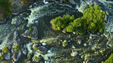 swirling streams of a mountain river with a rocky shore and forest, a close-up view from a drone, national treasure of nature in the Urals. Russia.