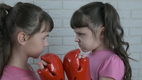 Boxing child competition. A view of a two little girl in boxing gloves in the room.