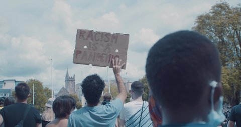 Bristol, UK - June 07 2020: People with "Racism is a Pandemic" sign at Black Lives Matter march
