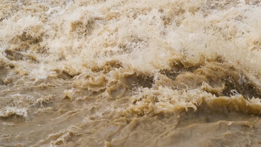 Dirty river with muddy yellow water in flooding period during heavy rains in spring. | Shutterstock HD Video #1054703708