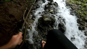 First-person video of a jungle to a cliff on a high mountain with a rock river and green trees