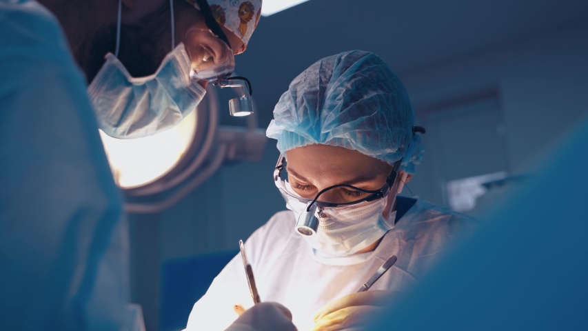 Doctor during surgery in operating room. Professional doctor performing operation in surgery room Royalty-Free Stock Footage #1054706714